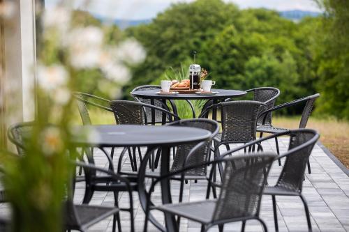 a table and chairs on a patio with coffee cups at Bieszczadzkie Siedlisko in Polańczyk
