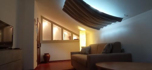 Appartamento mansardato iPatrizi في مونكالييري: غرفة معيشة مع أريكة ونافذة