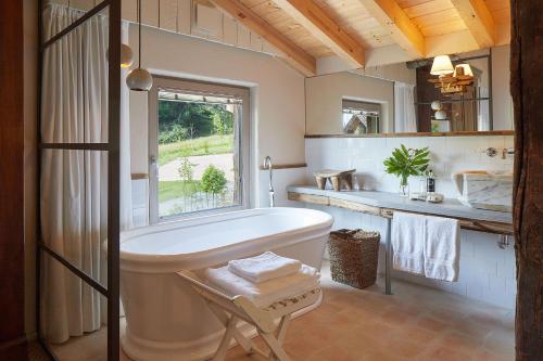 a bathroom with a tub and a window and a sink at OAR Cottage in Durango