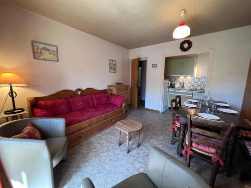 un salon avec un canapé rouge et une table dans l'établissement Crepuscule 3 - Appartement proche pistes de ski et village, à La Clusaz