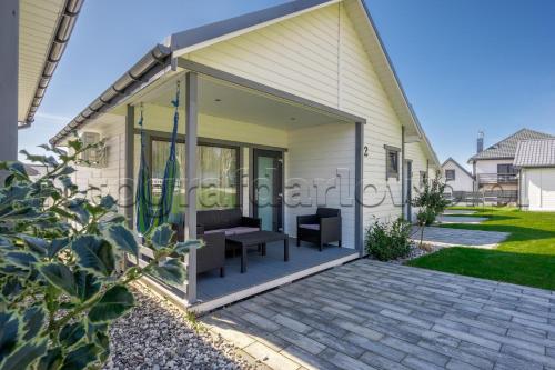 a glass extension of a house with a patio at Domki letniskowe Alma, Jarosławiec in Jarosławiec