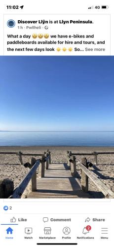 a tweet about a beach with a wooden pier at The Cwtch - a self contained one bedroom annex in Pwllheli