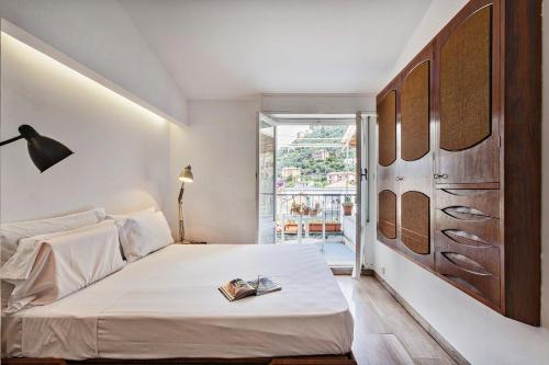 Un dormitorio con una cama con un libro. en Stunning Sea View Apartment with Terrace in Camogli by Wonderful Italy, en Camogli