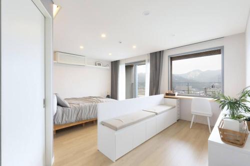 a white bedroom with a bed and a desk at PPP Seoul in Seoul