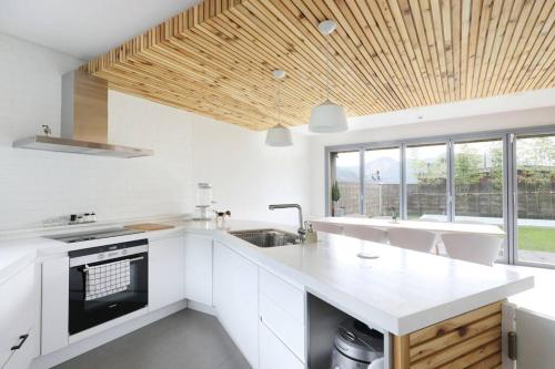 a kitchen with white cabinets and a wooden ceiling at PPP Seoul in Seoul