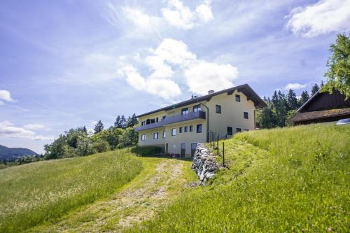 a house on top of a hill with a dirt road at Appartments Kramer in Schiefling am See