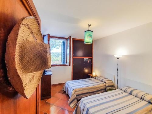 a room with two beds and a window at Trilocale La Pineta Quiet garden in Marina di Campo