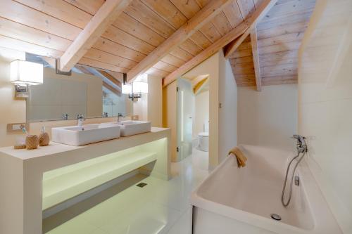 a bathroom with two sinks and a tub at Chryssi Akti Family Villa and Studios in Argassi