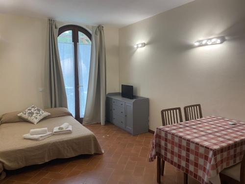 a bedroom with two beds and a table and a television at Residenza Cipressi e Olivi in Verona