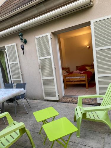 a patio with chairs and a table and a bedroom at LE CLOS D'HERBLAY Chambres d'Hôtes in Herblay