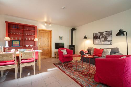 a living room with red furniture and a dining room at Ferienhof Homann Sauerland in Brilon