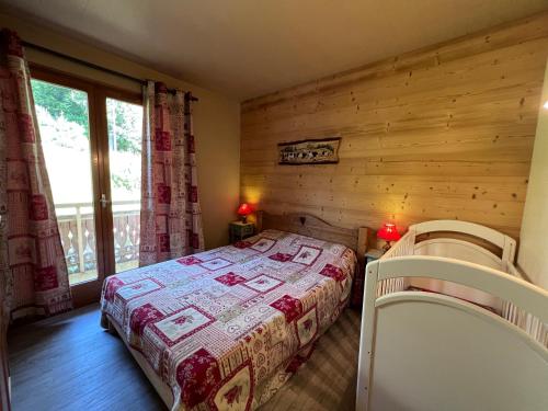 une chambre avec un lit et une grande fenêtre dans l'établissement Crepuscule 4 - Appartement proche pistes de ski et village, à La Clusaz