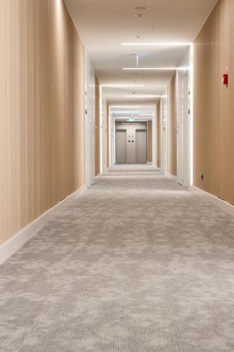 an empty corridor of an office building with white walls at PINEA Apartments Pobierowo z niesamowitym widokiem na morze oraz jacuzzi w wybranych apartamentach in Pobierowo