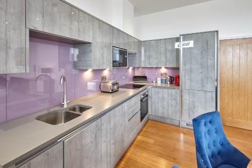 eine Küche mit einem Waschbecken und einem blauen Stuhl in der Unterkunft Host & Stay - Chilton at Carlill House in Whitby