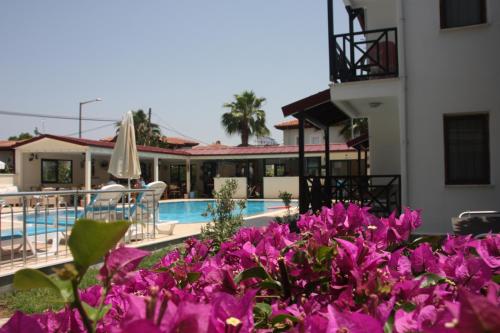 a bunch of purple flowers in front of a pool at Loya Vita Hotel in Dalyan