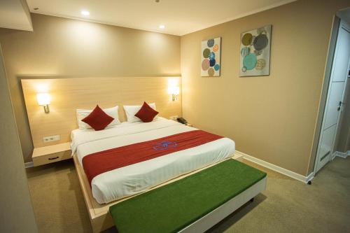 a hotel room with a large bed with red pillows at B Hotel Bishkek in Bishkek