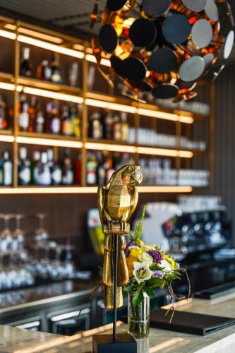 a statue of a bird sitting on a counter with flowers at Hotel Medistone in Omiš
