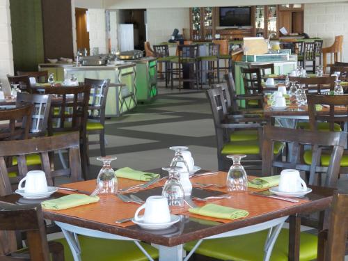 uma sala de jantar com mesas e cadeiras de madeira em Radisson Aquatica Resort Barbados em Bridgetown