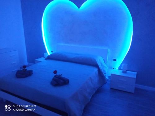 a bedroom with a heart shaped bed with two shoes on it at Appartamento con SPA I Due cuori in Taranto