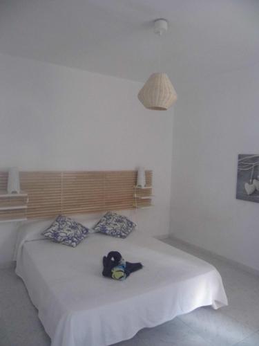 a stuffed animal sitting on a bed in a bedroom at Apartamento Hércules in Costa Del Silencio