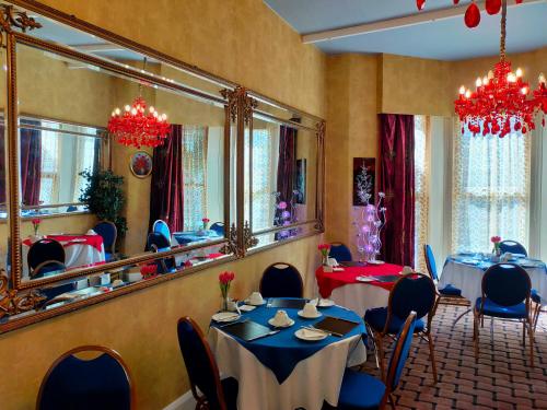 a dining room with two tables and a large mirror at Hotel Babylon in Blackpool