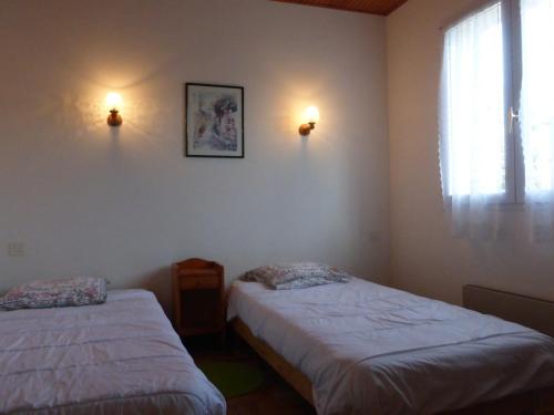 - une chambre avec deux lits, une fenêtre et deux lumières dans l'établissement Maison à 2 km de la plage avec terrasse, jardin et garage à Brem-sur-Mer - FR-1-224A-27, à Brem-sur-Mer