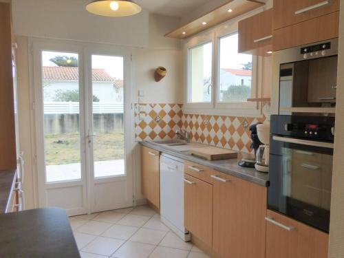 une cuisine avec un évier et une cuisinière four supérieur dans l'établissement Maison de vacances 3 chambres près mer, jardin, terrasse, wifi, calme, 6 couchages - Bretignolles - FR-1-224A-19, à Bretignolles-sur-Mer