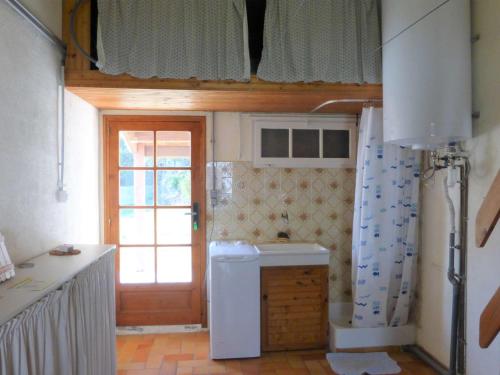 une petite cuisine avec un évier et une porte. dans l'établissement Maison plain pied tout confort, proche plage, 6 couchages, terrasse, 2 chambres, parking, Wi-Fi optionnel - FR-1-224A-383, à Bretignolles-sur-Mer