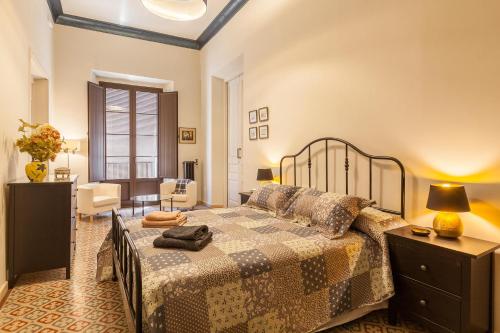 Un dormitorio con una cama grande y una sala de estar en Apartament Merlot, en Vilafranca del Penedès