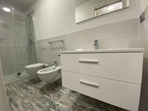 une salle de bain blanche avec un lavabo et des toilettes dans l'établissement Sainte-Maxime : studio 2 pers refait à neuf avec clim, jardin et parking - FR-1-226-299, à Sainte-Maxime