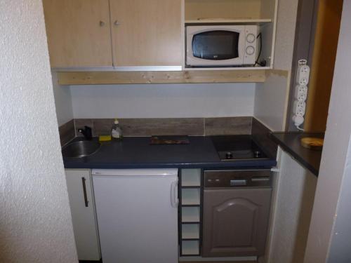 une petite cuisine avec un évier et un micro-ondes dans l'établissement Charmant Studio Lumineux au Hameau, à 150m des Pistes, WiFi Inclus - FR-1-292-181, à Isola