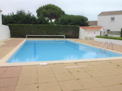 une grande piscine bleue dans une cour dans l'établissement Appartement 2 pièces, 3 couchages, piscine chauffée, proche plage et commerces à Bretignolles-sur-Mer - FR-1-224A-45, à Bretignolles-sur-Mer