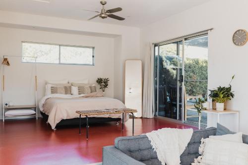 um quarto com uma cama e um sofá em S T U D I O 22 Peaceful Retreat with Garden Views em Port Lincoln