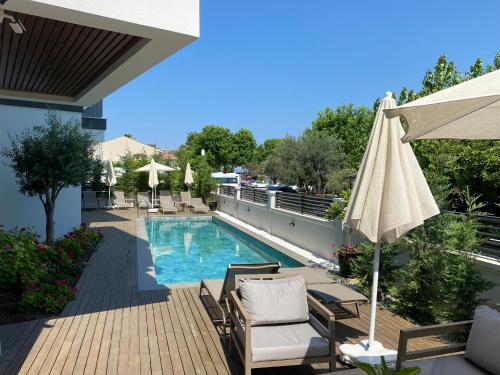 a swimming pool with chairs and an umbrella at Avilia Suites in Fethiye