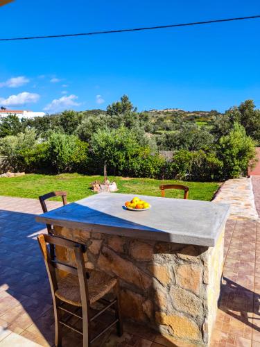 a stone table with a plate of fruit on it at Villa Alexander 2 in Triopetra