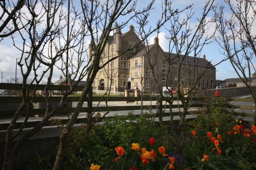 an old building with flowers in front of it at Islesburgh House Hostel in Lerwick