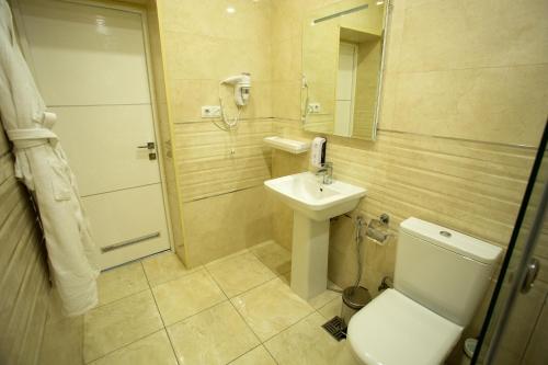 a bathroom with a toilet and a sink and a mirror at B Hotel Bishkek in Bishkek