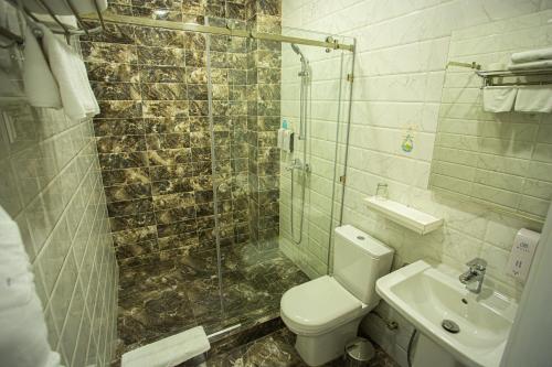 a bathroom with a toilet and a sink and a shower at B Hotel Bishkek in Bishkek