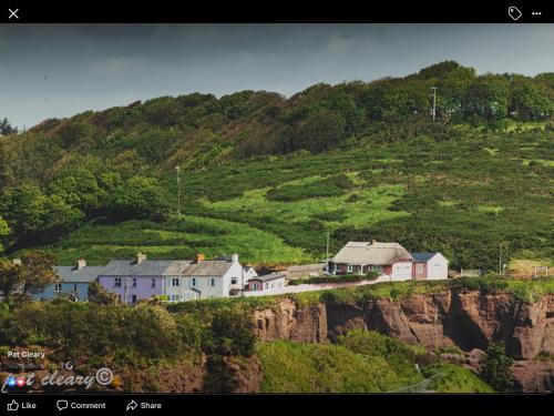 a group of houses on the side of a mountain at Cliff cottage in Dunmore East
