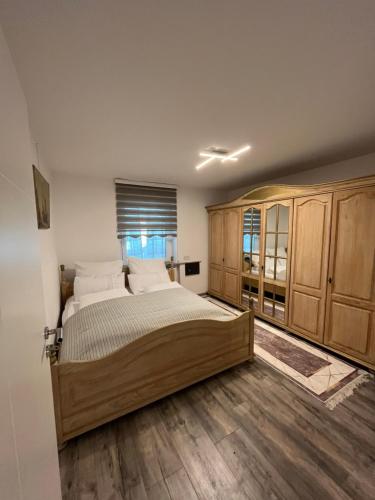 a bedroom with a large bed and wooden cabinets at Villa Dijamant 