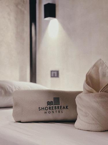 a hotel room with a towel on a bed at Shorebreak Hostel San Juan La Union in san juan la union