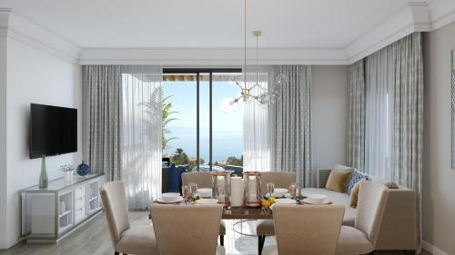a dining room with a table and chairs and a television at Carmen Residence Apartments in Opatija