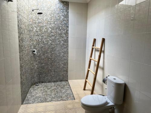 a bathroom with a shower with a toilet in it at Bingin Family Bungalow in Uluwatu