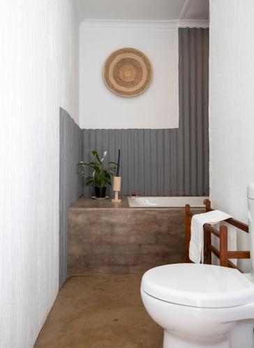 a bathroom with a toilet and a bath tub at Springvale Farm in Nottingham Road