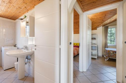 a bathroom with a sink and a toilet and a bedroom at La Casa di Lady in Ceriale