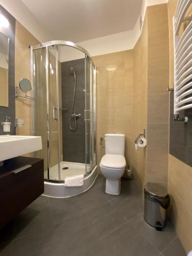 a bathroom with a shower and a toilet and a sink at Ośrodek Warszawianka in Świnoujście