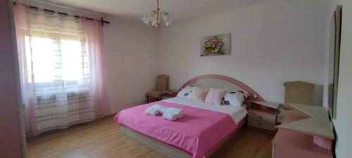a bedroom with a pink bed with two stuffed animals on it at Apartment Eva in Rovinjsko Selo
