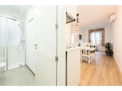 a bathroom with a glass door and a dining room at Apartamento 3 Habs enfrente de Atocha Mendez3º in Madrid