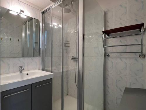 une salle de bain avec une douche en verre et un lavabo dans l'établissement Villa T3 en bord de mer avec piscine, 6 personnes - Le Barcarès - FR-1-81-494, au Barcarès