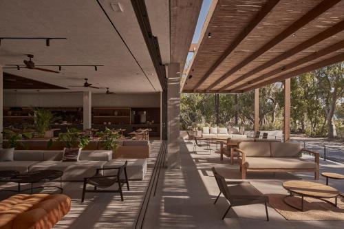 an outdoor lounge with tables and couches and chairs at Theros All Suite Hotel - Adults Only in Kos Town